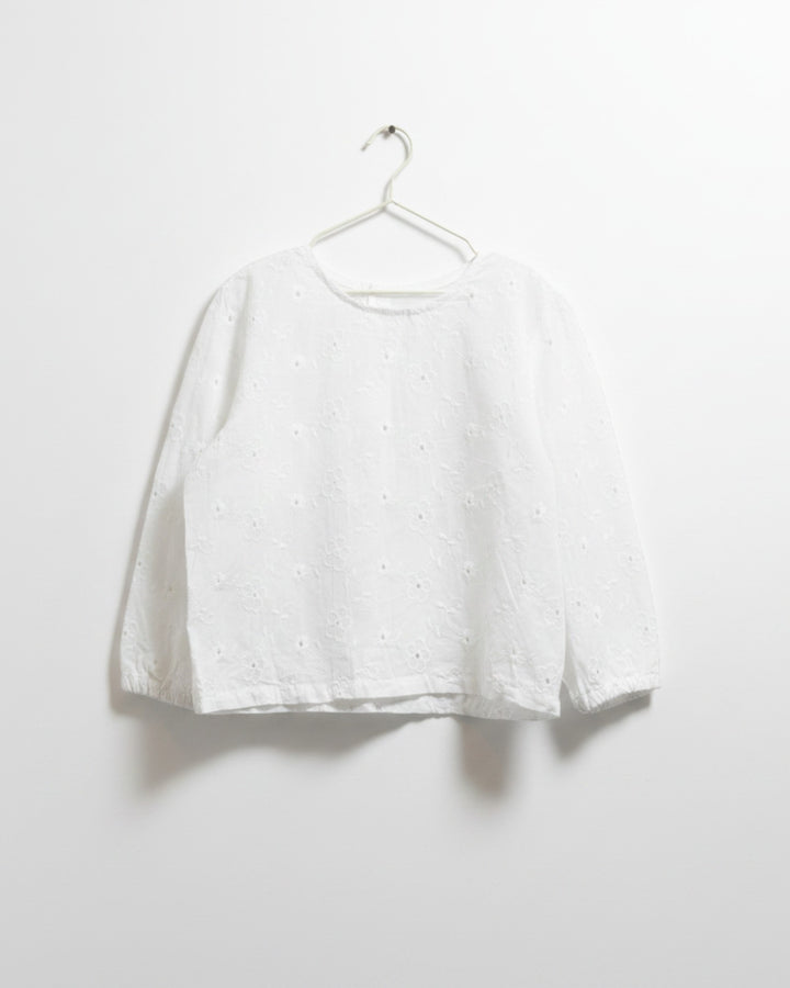 Blusa blanca Kankla de manga larga con bordado floral y botones traseros.
