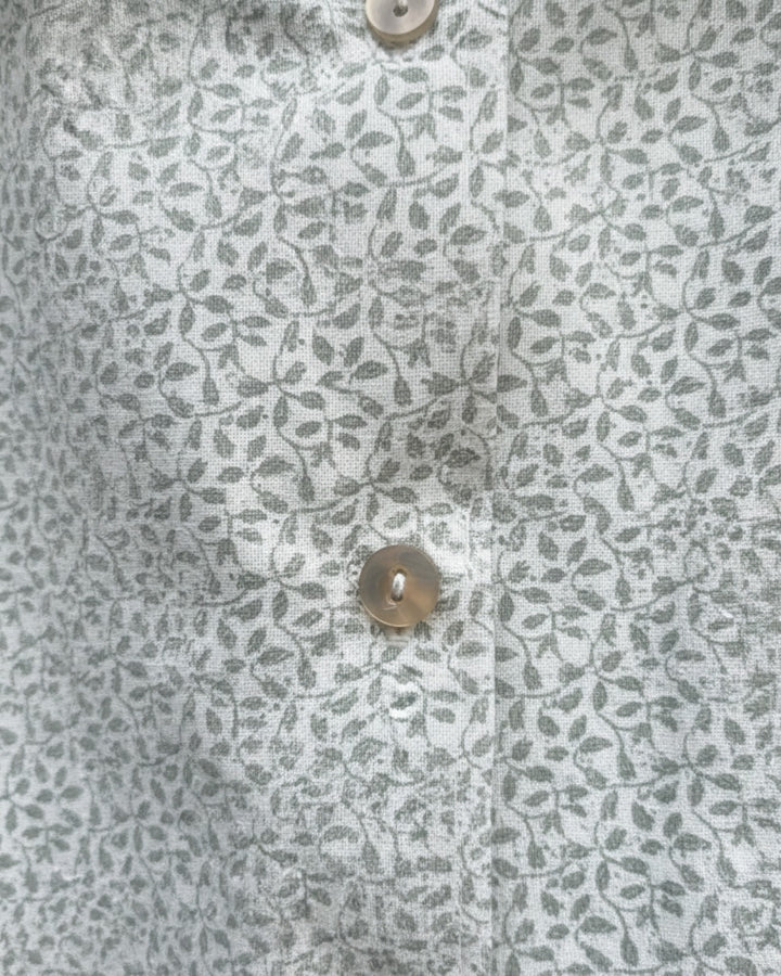 Blusa Kankla de algodón 100% con estampado de hojas grises y botones frontales.