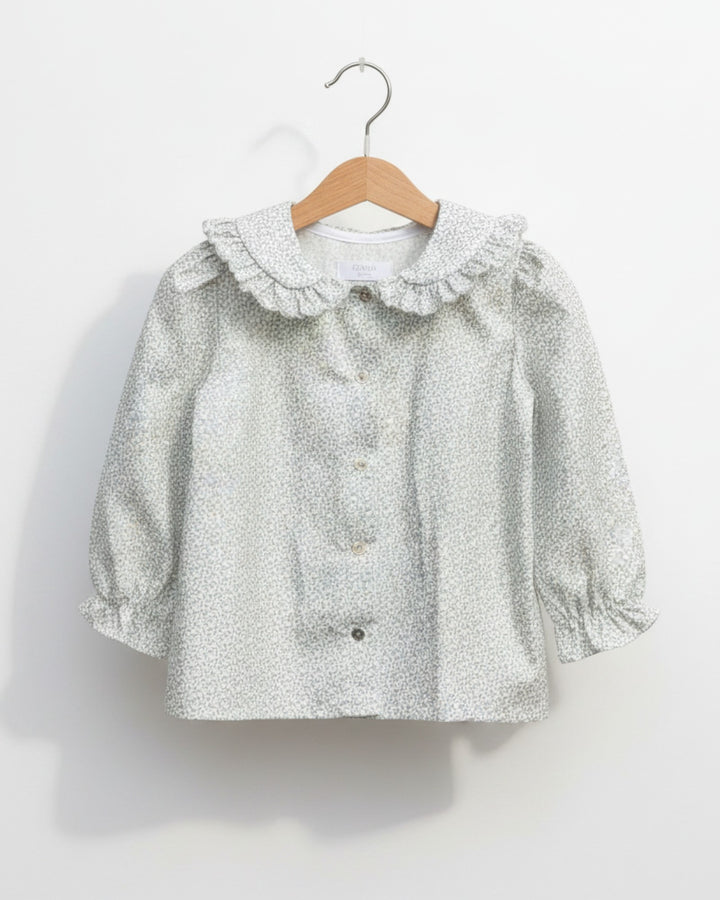 Blusa Kankla de algodón 100% con estampado de hojas grises, cuello volante y manga larga.