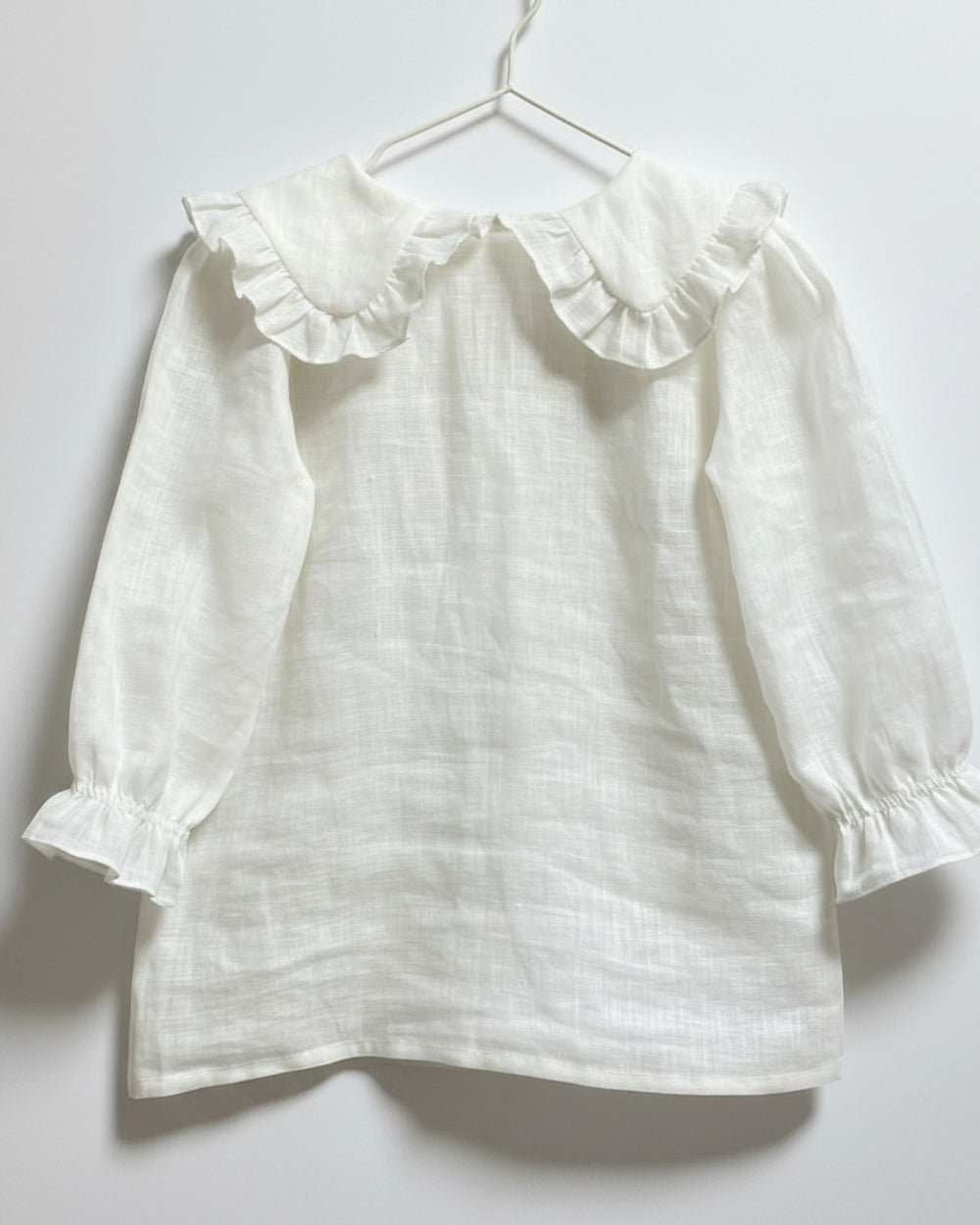 Blusa Kankla de lino crudo con cuello volante y manga larga abullonada.