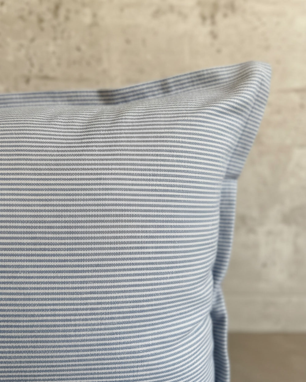 Funda de cojín Kankla de algodón azul con diseño de líneas finas y cierre invisible, fabricada en Chile.