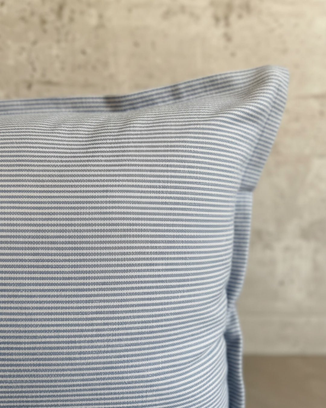 Funda de cojín Kankla de algodón azul con diseño de líneas finas y cierre invisible, fabricada en Chile.