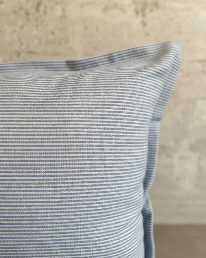 Funda de cojín Kankla de algodón azul con diseño de líneas finas y cierre invisible, fabricada en Chile.
