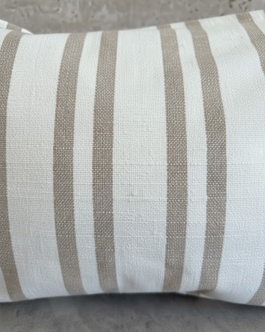 Funda de cojín Kankla de algodón beige con diseño de rayas verticales, textura natural y cierre invisible.