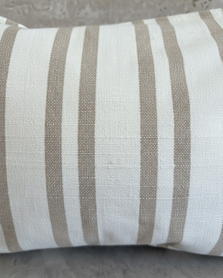 Funda de cojín Kankla de algodón beige con diseño de rayas verticales, textura natural y cierre invisible.