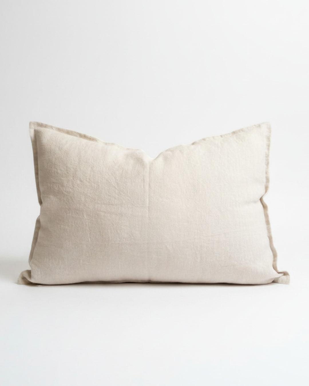Funda de cojín Kankla de lino natural beige de alto gramaje con borde de pestaña y cierre invisible.