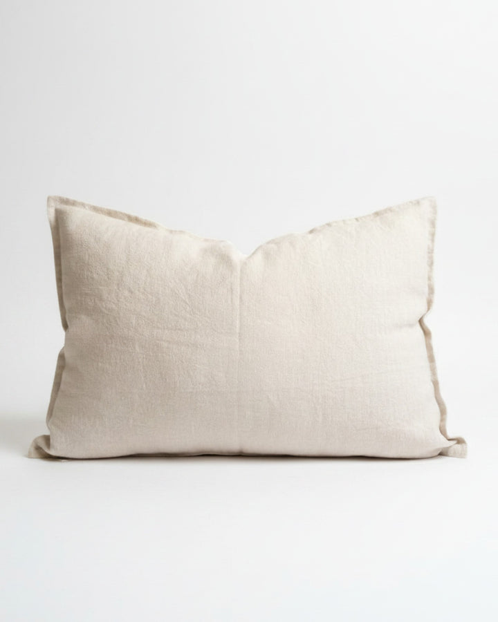 Funda de cojín Kankla de lino natural beige de alto gramaje con borde de pestaña y cierre invisible.