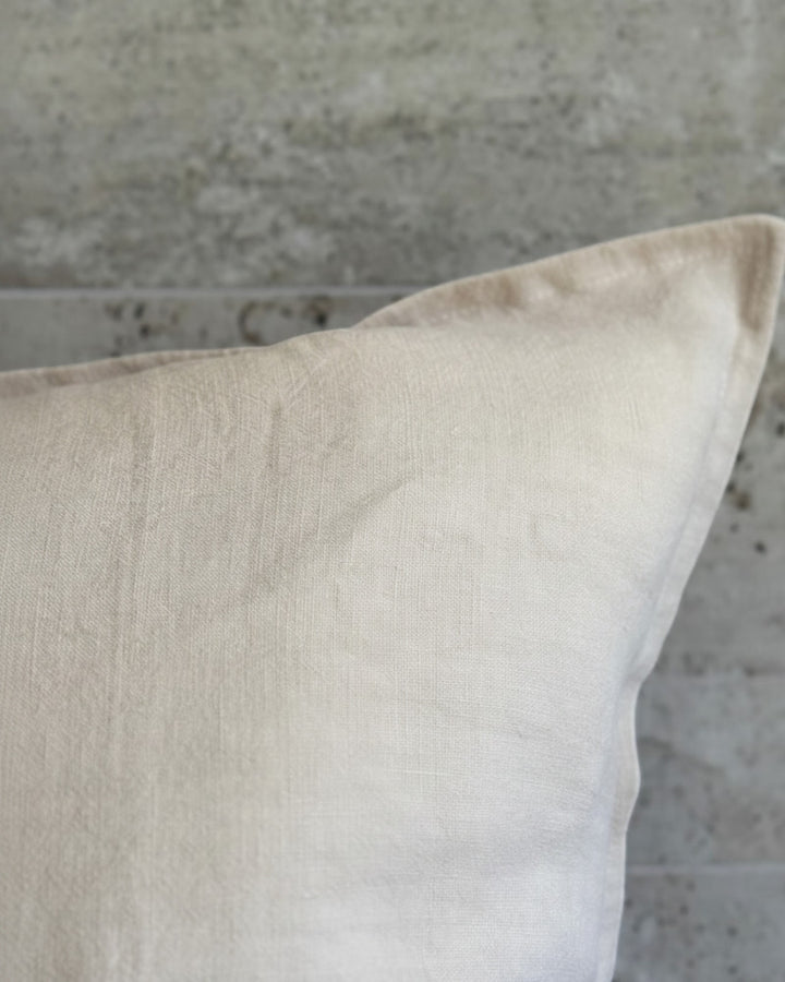 Funda de cojín Kankla de lino natural beige de alto gramaje con borde de pestaña y cierre invisible. 60x40 cm.