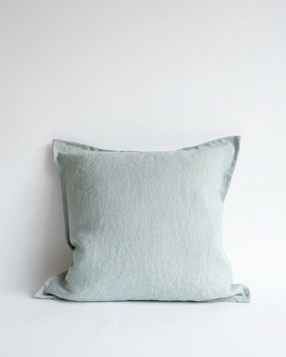 Funda de cojín Kankla Puelo en lino color verde agua con borde de pestaña y cierre invisible.