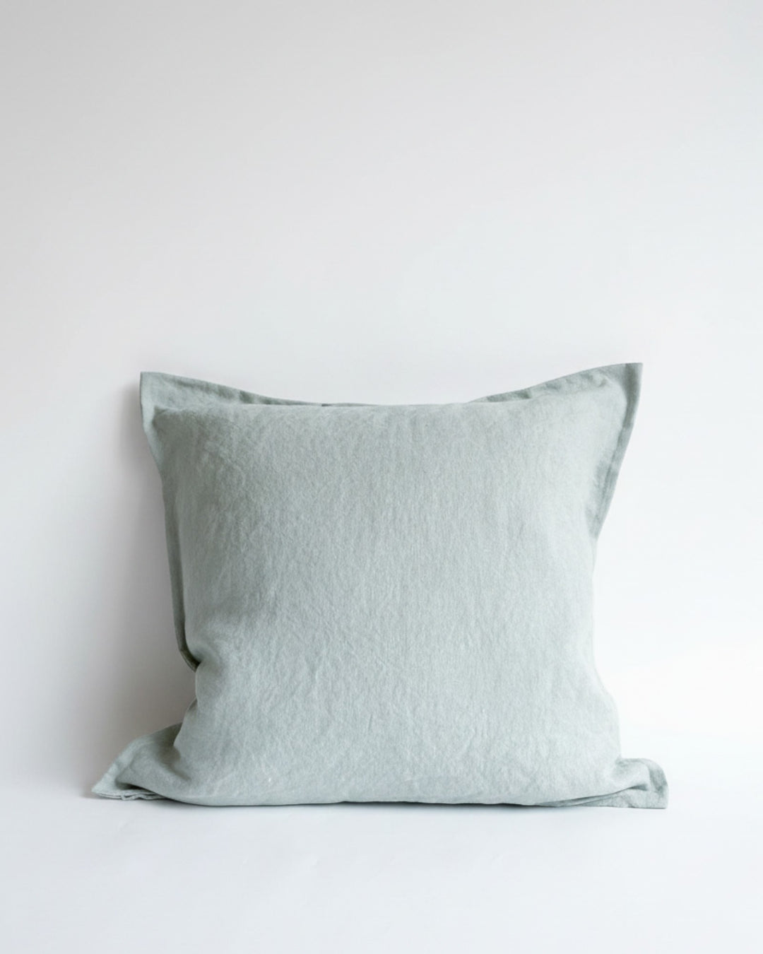 Funda de cojín Kankla Puelo en lino color verde agua con borde de pestaña y cierre invisible.