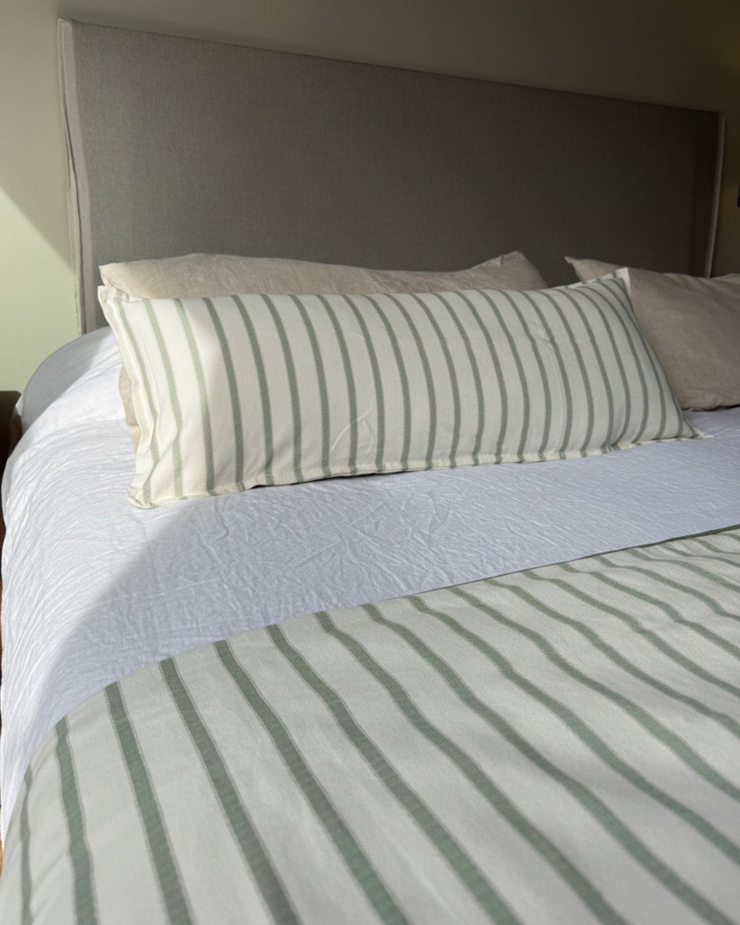 Piecera reversible Kankla de algodón verde con diseño de líneas y relleno removible sobre cama