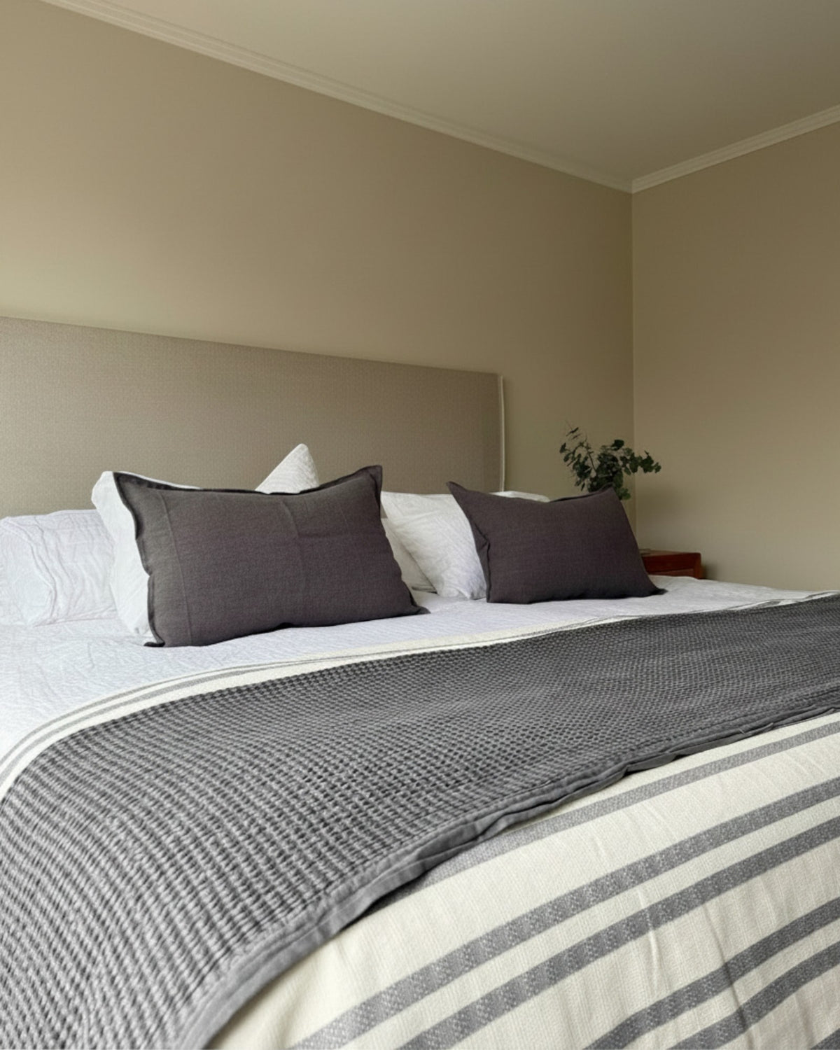 Piecera Kankla Mónaco gris oscuro reversible de algodón y lino con diseño de líneas sobre cama matrimonial