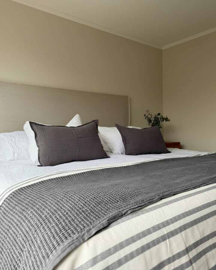 Piecera Kankla Mónaco gris oscuro reversible de algodón y lino con diseño de líneas sobre cama matrimonial
