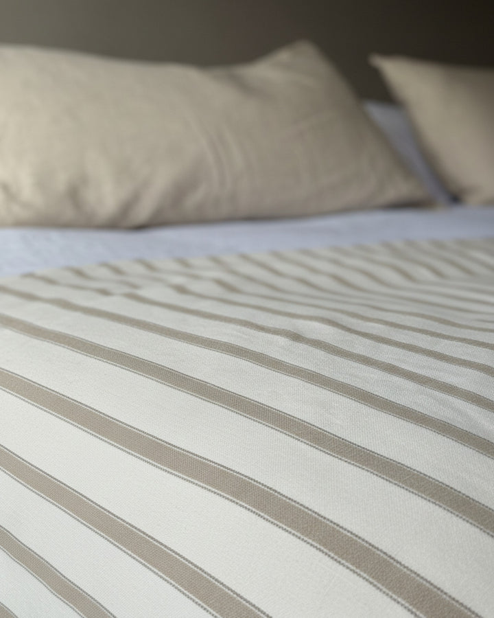 Piecera Kankla Niza reversible de algodón con rayas beige y lino greige, incluye relleno removible para cama.